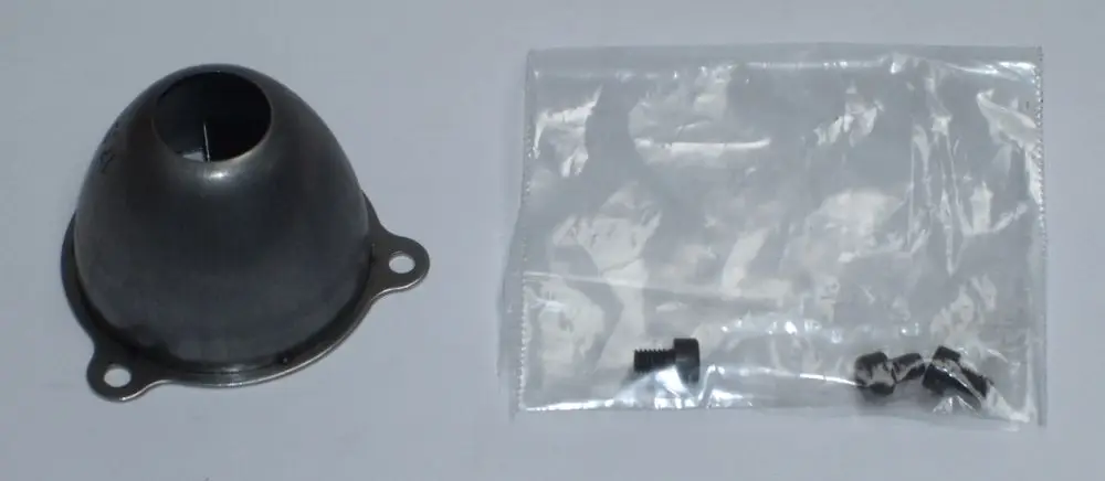 Daikin-Luftdüse aus Metall in konischer Form mit Öffnung oben, daneben eine transparente Tüte mit Schrauben.